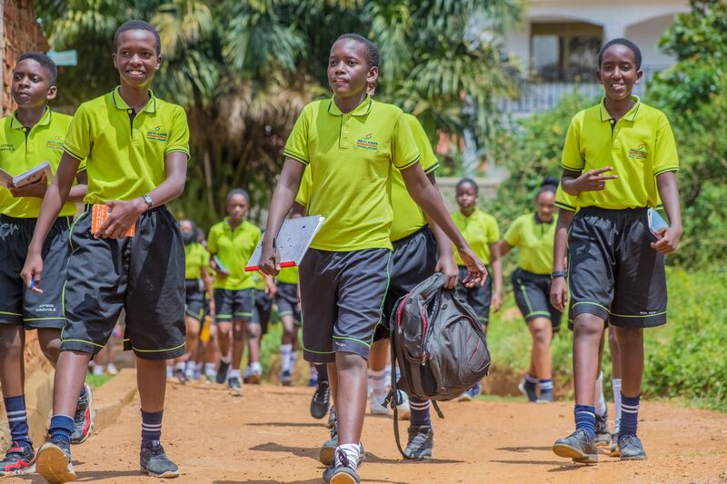 Pupils in uniform walking through a school compound